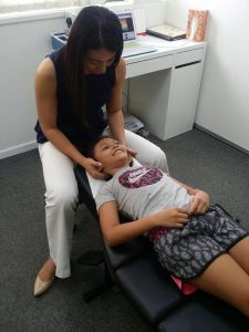Dr Jenny treating her child patient's neck