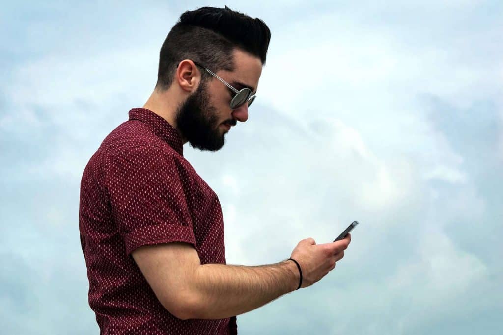 Man holding a Phone and lowering his neck