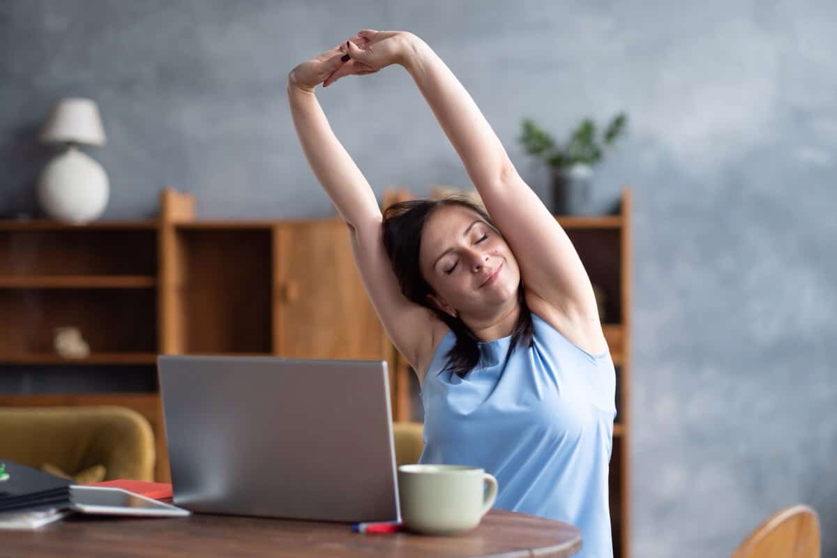 woman doing some stretching exercises in home office