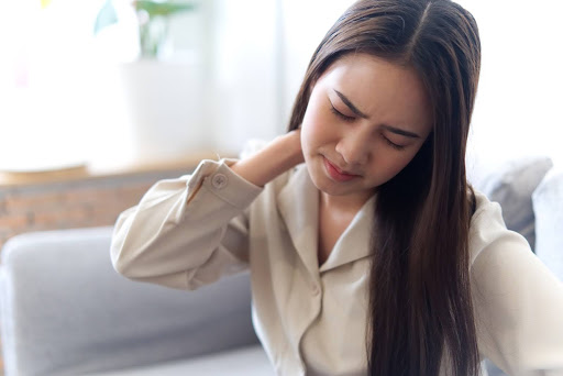 A woman suffering from neck pain A woman suffering from neck pain