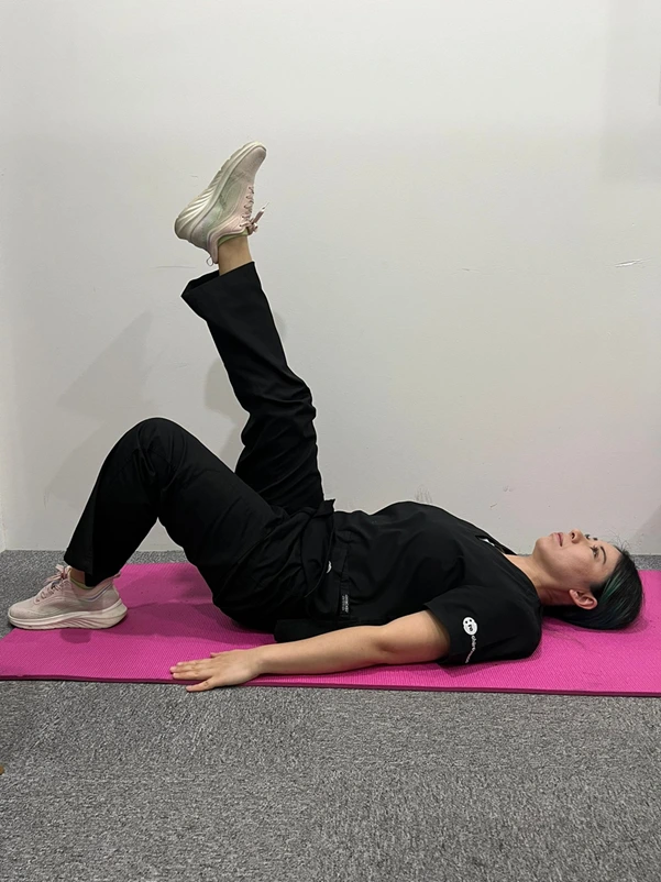 A woman doing a straight leg raise exercise A woman doing a straight leg raise exercise