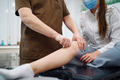 A skilled chiropractor performing a physical examination and treatment on a female patient's knee